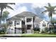 Elegant home with a gray tiled roof, light stucco, blue shutters, and well manicured shrubbery at 3550 Flamingo Ave, Sarasota, FL 34242