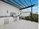 Modern outdoor kitchen with granite counters, stainless steel grill and a pergola covered patio for outdoor cooking and dining at 3550 Flamingo Ave, Sarasota, FL 34242