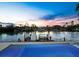 Tranquil sunset view from the pool with dock, palm trees, and colorful sky reflecting on calm water creates peaceful ambiance at 3550 Flamingo Ave, Sarasota, FL 34242