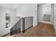 Modern staircase featuring wood steps, black railings, and natural lighting from a nearby window at 3550 Flamingo Ave, Sarasota, FL 34242