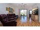 Living room featuring comfortable leather furniture, a ceiling fan, and sliding doors to a screened porch at 5230 Hyland Hills Ave # 1315, Sarasota, FL 34241