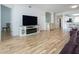 Living room showcasing an entertainment center, adjacent dining area, and hardwood style flooring at 5230 Hyland Hills Ave # 1315, Sarasota, FL 34241