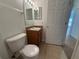 Bathroom featuring a toilet, vanity sink with brown cabinet, and neutral tiled floors at 14812 Skip Jack Loop, Lakewood Ranch, FL 34202