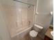 Clean bathroom featuring a bathtub, shower, and toilet with neutral tile surround at 14812 Skip Jack Loop, Lakewood Ranch, FL 34202
