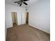 Large carpeted bedroom with a ceiling fan and closet and doors at 14812 Skip Jack Loop, Lakewood Ranch, FL 34202