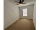 Empty bedroom with carpet, white walls, window, and modern ceiling fan at 14812 Skip Jack Loop, Lakewood Ranch, FL 34202