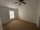 Carpeted bedroom with a ceiling fan and window that allows for natural lighting at 14812 Skip Jack Loop, Lakewood Ranch, FL 34202