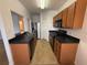 Efficient kitchen features wood cabinets, black countertops, and modern appliances at 14812 Skip Jack Loop, Lakewood Ranch, FL 34202