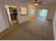 Open-concept living room with ceiling fan and sliding glass doors to a serene lake view at 14812 Skip Jack Loop, Lakewood Ranch, FL 34202