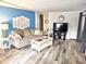 Living room with blue accent wall, comfy seating, and a large TV at 10 White Oak Ter, Sarasota, FL 34237