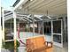 Relaxing screened porch with a wooden swing and access to the backyard at 2760 Chipley Ave, North Port, FL 34286