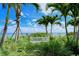 Beautifully landscaped view with mature palm trees and white bench overlooking the ocean at 360 Gulf Of Mexico Dr # 322, Longboat Key, FL 34228