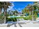 Beautiful pool area featuring a decorative white bench and trellis covered in flowering vines at 360 Gulf Of Mexico Dr # 322, Longboat Key, FL 34228