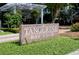 Close-up of the Tangerine Bay Club sign set amongst the lush landscaping on the property at 360 Gulf Of Mexico Dr # 322, Longboat Key, FL 34228