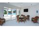 Bright sunroom with tile floors, wicker furniture, and sliding doors to the pool at 360 Gulf Of Mexico Dr # 322, Longboat Key, FL 34228