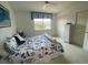 Comfortable bedroom with coastal-themed bedding, a window with blinds, and a white wicker cabinet at 324 Madeira Cir, Tierra Verde, FL 33715