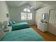 Cozy bedroom featuring twin beds with light teal bedding, a vaulted ceiling and a window offering natural light at 324 Madeira Cir, Tierra Verde, FL 33715