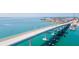 Scenic aerial view of a bridge over clear turquoise water, connecting to a residential area with waterfront properties at 324 Madeira Cir, Tierra Verde, FL 33715