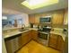 Kitchen featuring stainless steel appliances, granite countertops, and wooden cabinets at 324 Madeira Cir, Tierra Verde, FL 33715