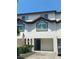 Two-story townhome with attached garage and American flag at 324 Madeira Cir, Tierra Verde, FL 33715