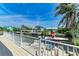 Beautiful waterfront view from the balcony, with a boat dock, and palm trees in a scenic outdoor setting at 523 Loquat Dr, Anna Maria, FL 34216