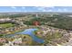 A serene aerial view of the neighborhood, showcasing a picturesque lake and lush green landscape at 6309 75Th E Ave, Palmetto, FL 34221