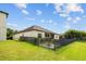 A fenced backyard features a deck, a firepit, lush greenery, and a well-maintained lawn at 6309 75Th E Ave, Palmetto, FL 34221