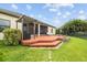 A beautiful backyard deck features a pergola, with a screened lanai, and a serene green lawn at 6309 75Th E Ave, Palmetto, FL 34221
