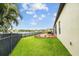 Backyard features a green lawn, patio, chaise lounge, a secure black metal fence, and water views at 6309 75Th E Ave, Palmetto, FL 34221