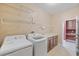 Well-lit laundry room with washer, dryer, storage shelves, sink and countertop space at 6309 75Th E Ave, Palmetto, FL 34221