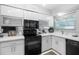 Updated kitchen with white cabinets and black appliances at 4660 Ocean Blvd # Q2, Sarasota, FL 34242