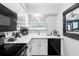 Modern kitchen with white cabinets and black appliances at 4660 Ocean Blvd # Q2, Sarasota, FL 34242