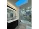 Modern bathroom with marble-look tile, skylight, and new fixtures over the vanity and in the walk-in shower at 5023 Inverness Dr, Sarasota, FL 34243