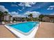 Clear blue community pool surrounded by lounge chairs and beautiful landscaping at 2611 Pine Lake Ter # B, Sarasota, FL 34237
