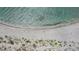 Aerial view of white sandy beach, clear turquoise ocean water, and sparse vegetation in a sought-after coastal community at 701 Armada S Rd, Venice, FL 34285