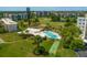 Community pool with surrounding lounge chairs and shuffleboard at 4440 Ironwood Cir # 108D, Bradenton, FL 34209