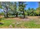 Landscaped backyard with mature trees and tennis court views at 4440 Ironwood Cir # 108D, Bradenton, FL 34209