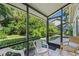 Screened porch with chairs and view of backyard at 4560 Forest Wood Trl # 16, Sarasota, FL 34241