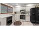 Well-equipped kitchen with black appliances and white cabinets at 4560 Forest Wood Trl # 16, Sarasota, FL 34241
