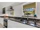 Modern kitchen with granite countertops, white cabinets, and a stylish backsplash at 701 Armada S Rd, Venice, FL 34285