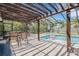Relaxing pool area with pergola, patio furniture, and a hot tub at 701 Armada S Rd, Venice, FL 34285