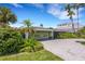 House exterior with a driveway and lush tropical landscaping at 701 Armada S Rd, Venice, FL 34285