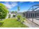 Side yard view with lush landscaping and a glimpse of the pool area at 701 Armada S Rd, Venice, FL 34285