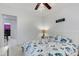 Bedroom with coastal bedding, ceiling fan, and view of dining area at 701 Armada S Rd, Venice, FL 34285