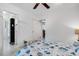 Bedroom with coastal bedding, ceiling fan, and view of dining area at 701 Armada S Rd, Venice, FL 34285