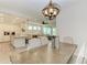 Open concept dining room with kitchen view and modern chandelier at 379 Aruba Cir # 202, Bradenton, FL 34209