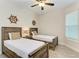 Guest bedroom with two twin beds, ceiling fan, and nautical decor at 379 Aruba Cir # 202, Bradenton, FL 34209