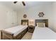 Well-lit bedroom with twin beds, nightstand, and ceiling fan at 379 Aruba Cir # 202, Bradenton, FL 34209