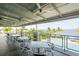 Covered patio with tables and chairs overlooking the pool and water at 379 Aruba Cir # 202, Bradenton, FL 34209