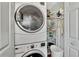 Laundry room with stackable washer and dryer, shelving, and ironing board at 6800 Placida Rd # 281, Englewood, FL 34224